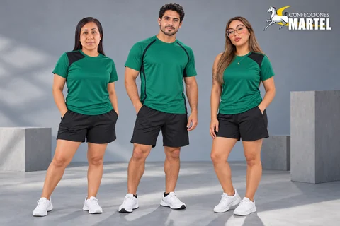Tres modelos adultos con camisetas esmeralda de paneles o ribetes negros y shorts negros.